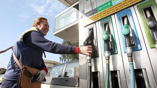 Una empleada surte a un vehículo en una estación de servicio