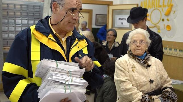 Un cartero entrega a primera hora de la mañana el voto por correo en un colegio electoral