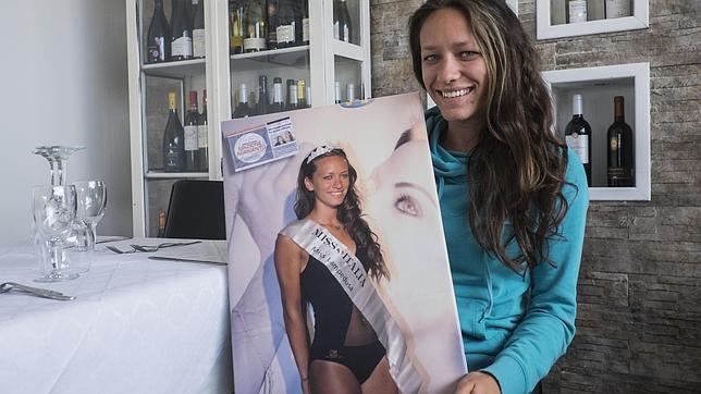 Zucchero posa en el restaurante L`Aragosta, donde trabaja, con su foto de Miss Lampedusa de 2011