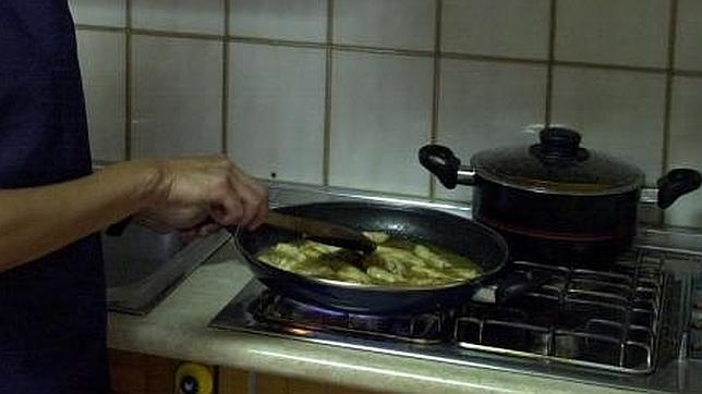 Una mujer cocina unos alimentos sobrantes